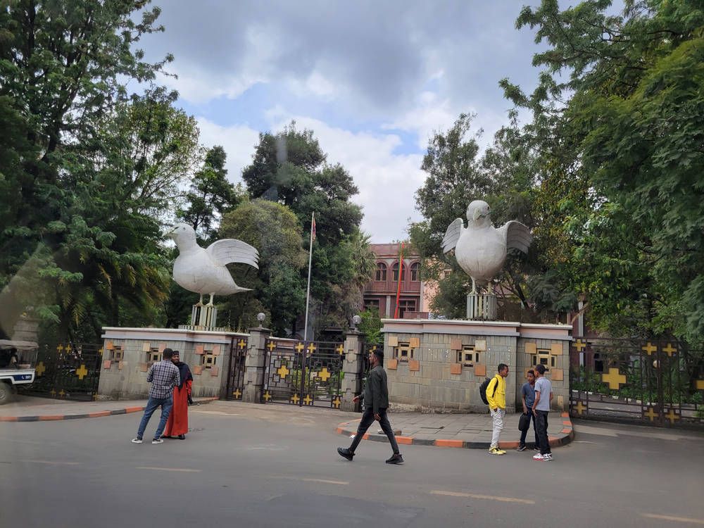 A gate with two white bird statues