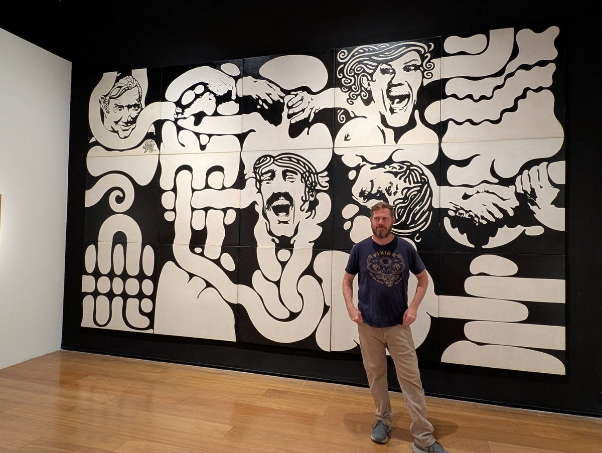 Brendan in front of a black and white mural