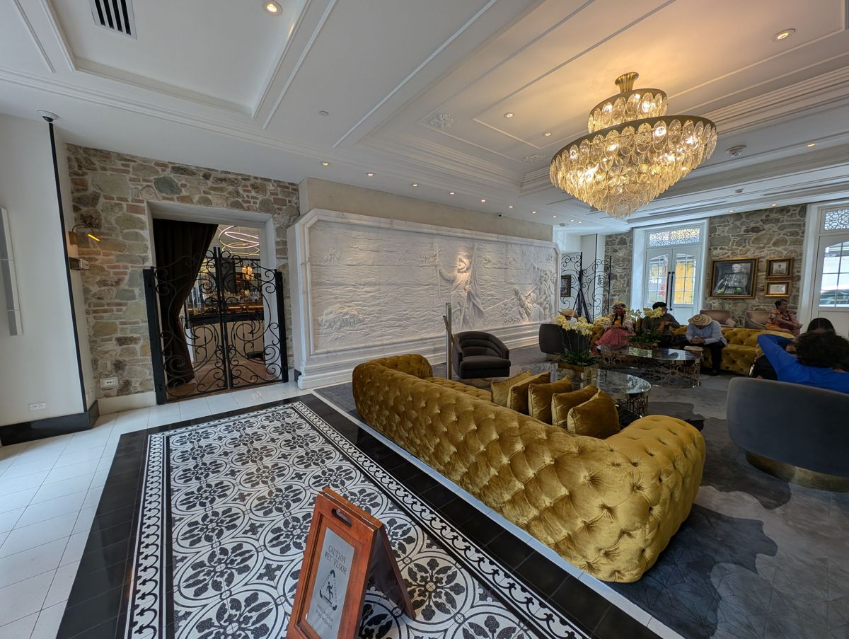 The lobby, with a carved marble relief and a gold velvet sofa