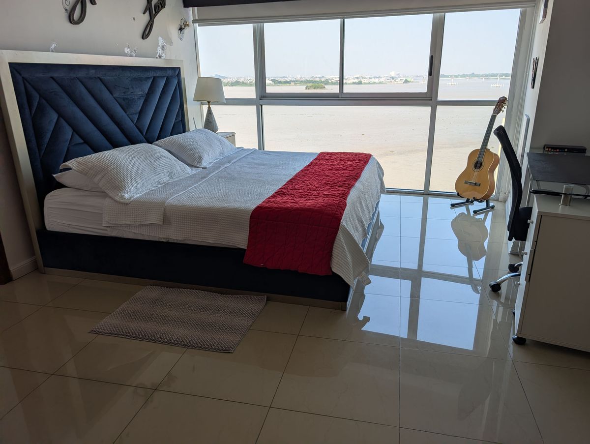 The bedroom, with a guitar and the river in the window