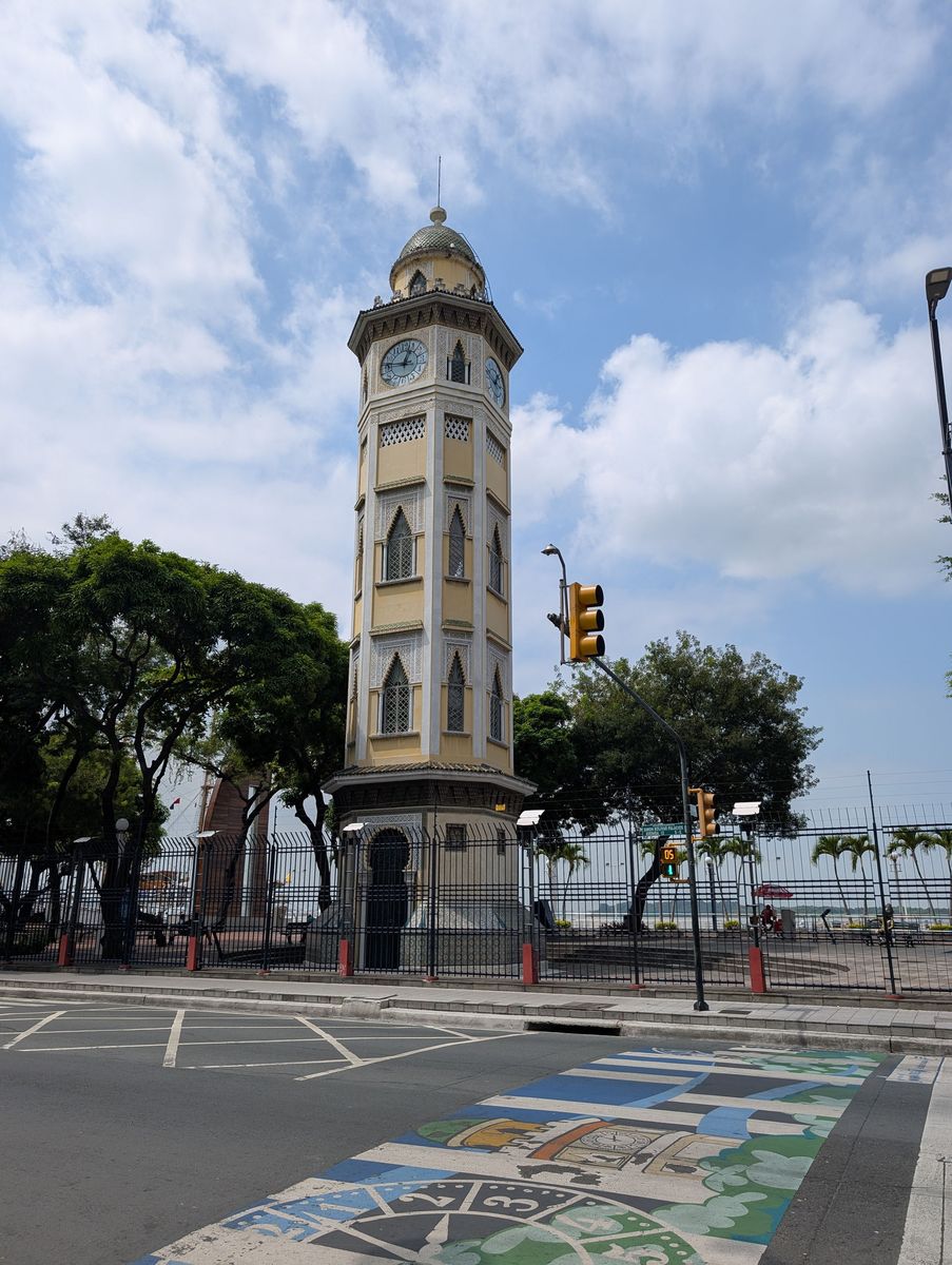 The clock tower from across the street, over a painted crosswalk