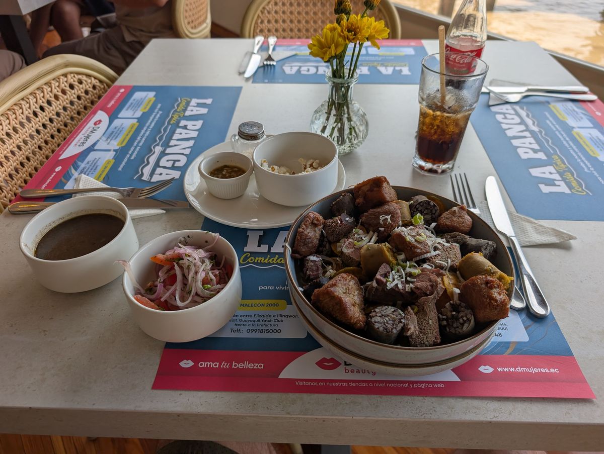 Comida típica: a soup, onion and tomato salad, canguil popcorn, ají, and a bowl of meats