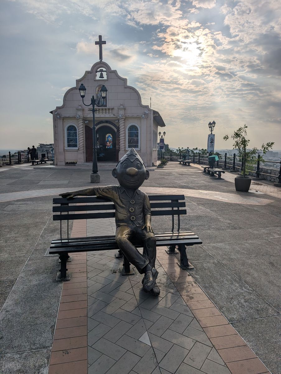 Juan Pueblo, the Guayaquil everyman a cartoonist created in 1918, on a bench by the chapel