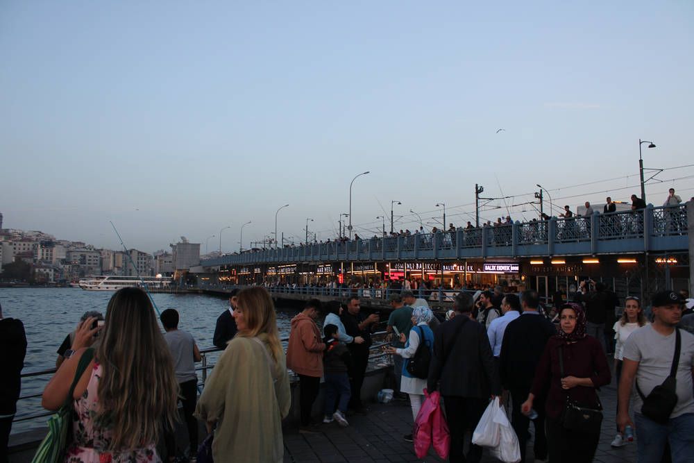 Crowds along the water by the bridge