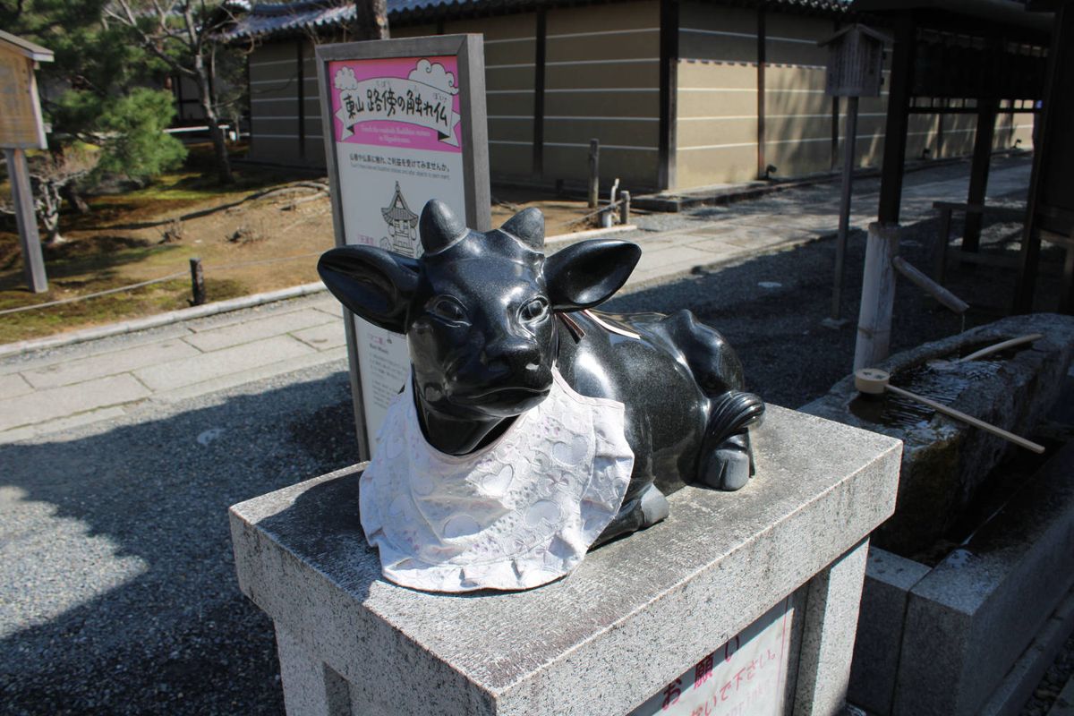 A bronze cow statue in a bib