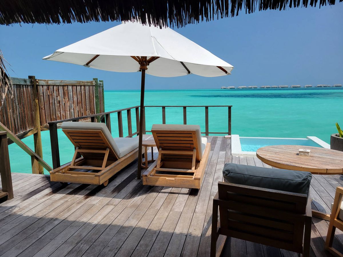 The villa deck: loungers, an umbrella and the lagoon
