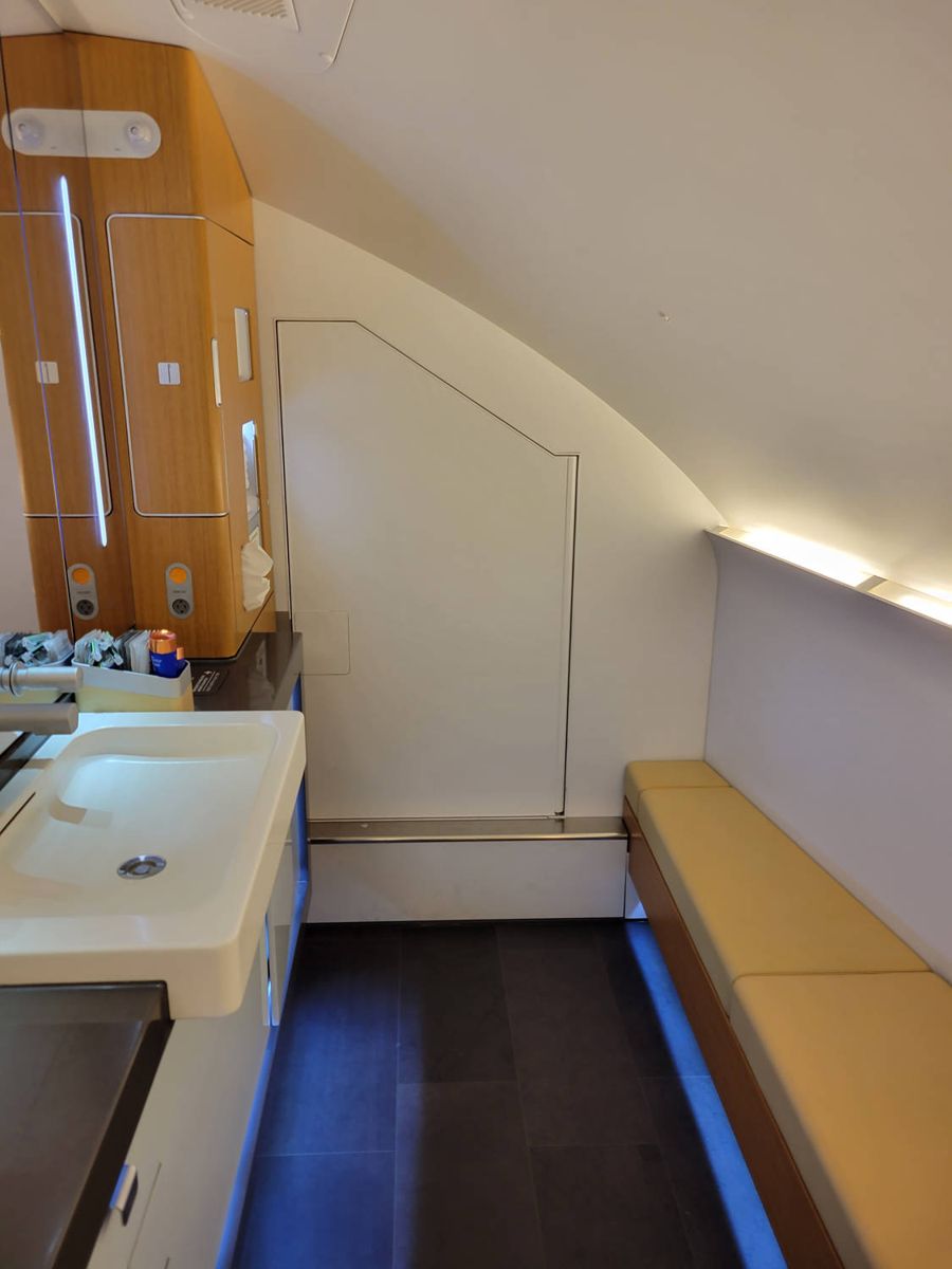 The urinal cabinet open next to the toilet