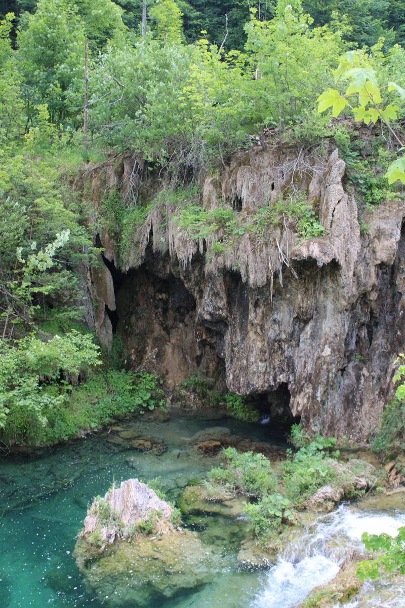 A cave over a turquoise pool
