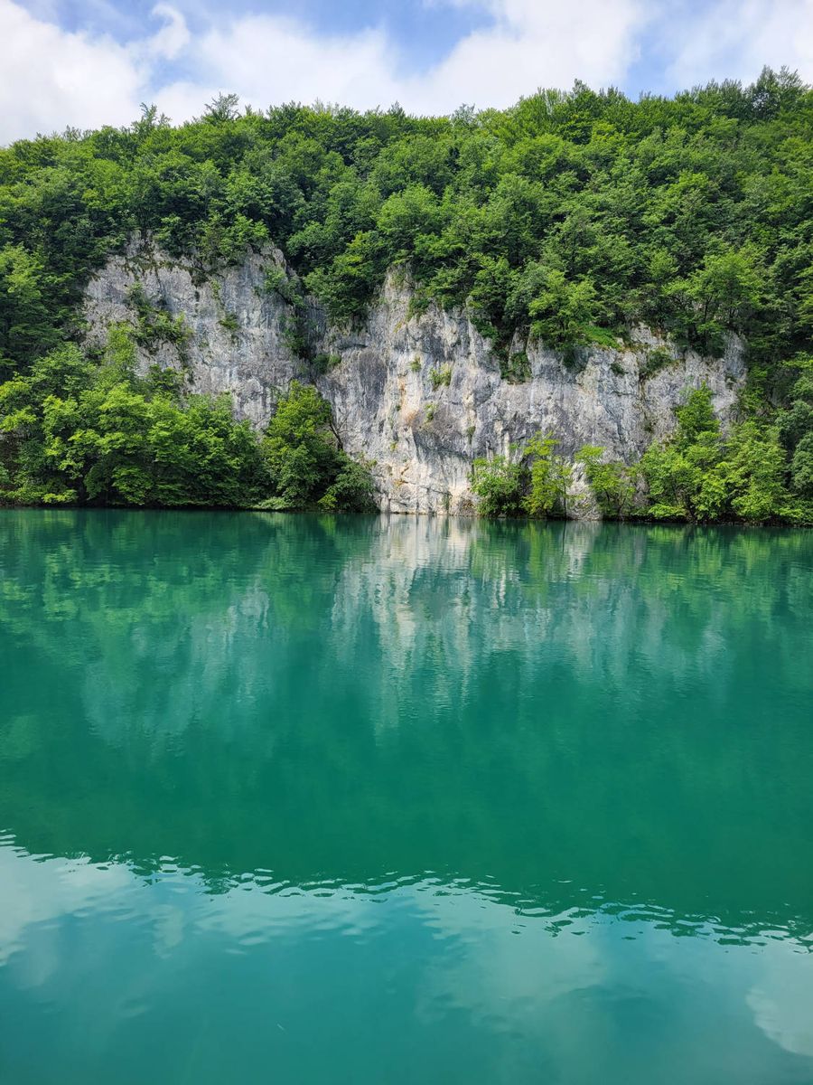 A cliff over still water