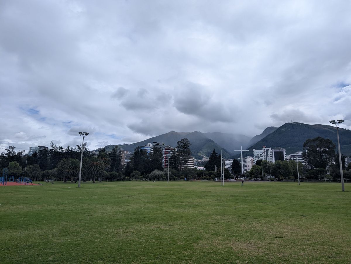 A big open field, the hills behind in cloud
