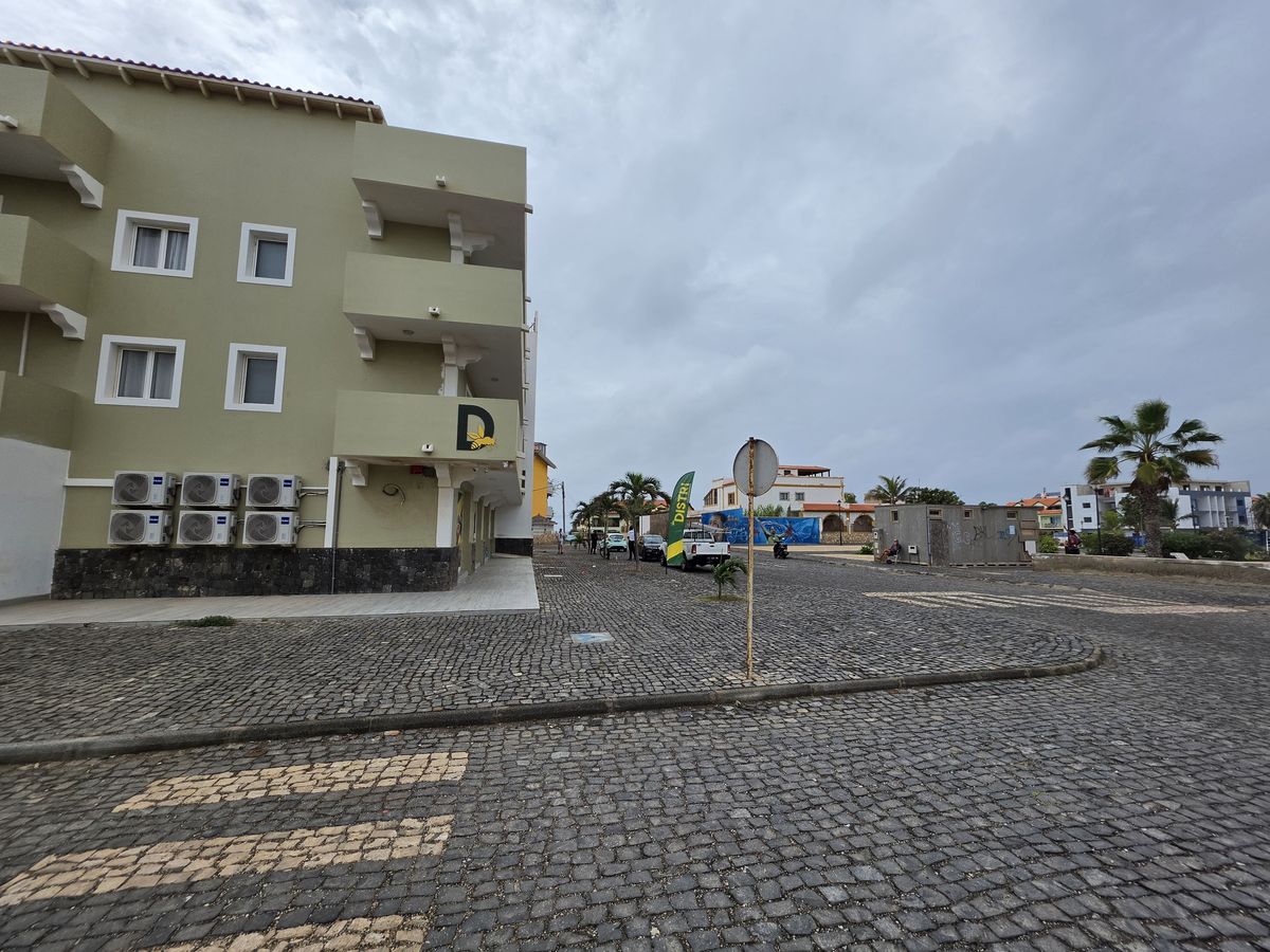 A green apartment block on a cobbled corner