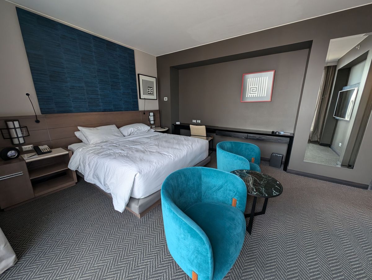 The bedroom, with velvet chairs and a marble side table