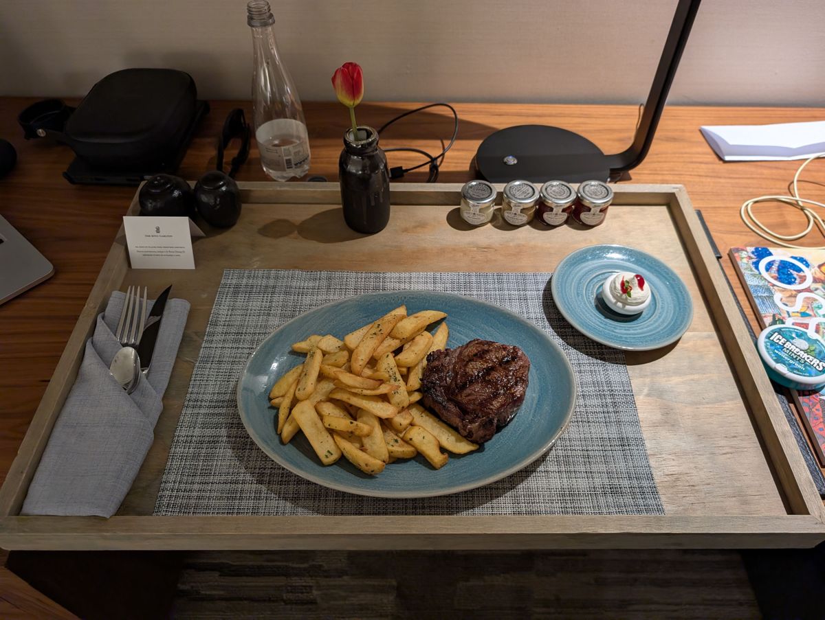 Room service steak and fries, with a tulip on the tray