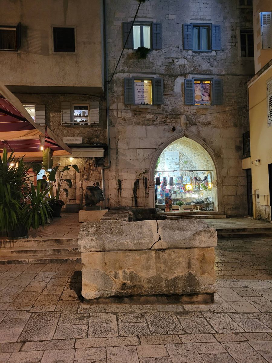 A lit archway off a small square