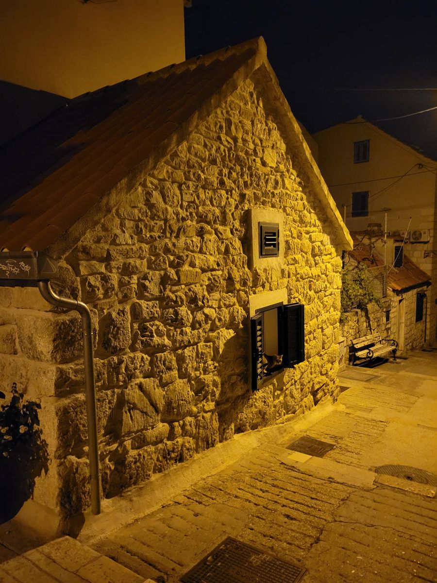 A stone house on a lamplit lane