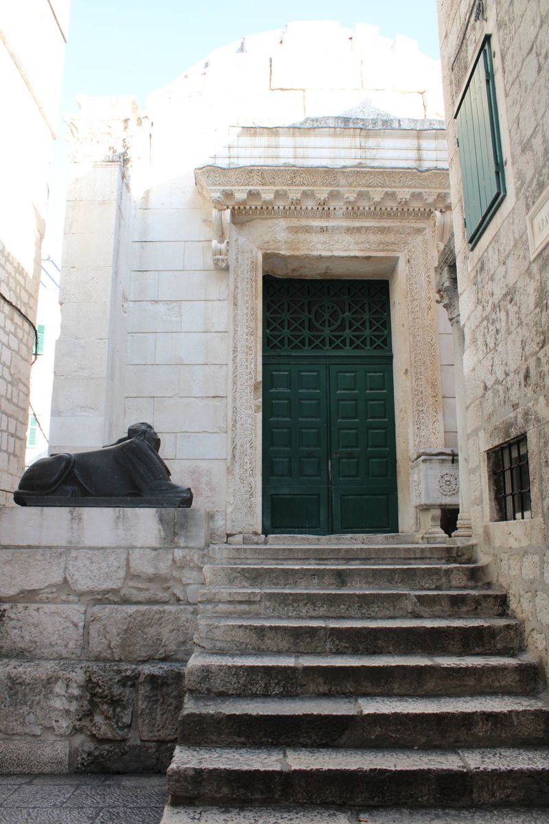 Steps to a temple door with a sphinx
