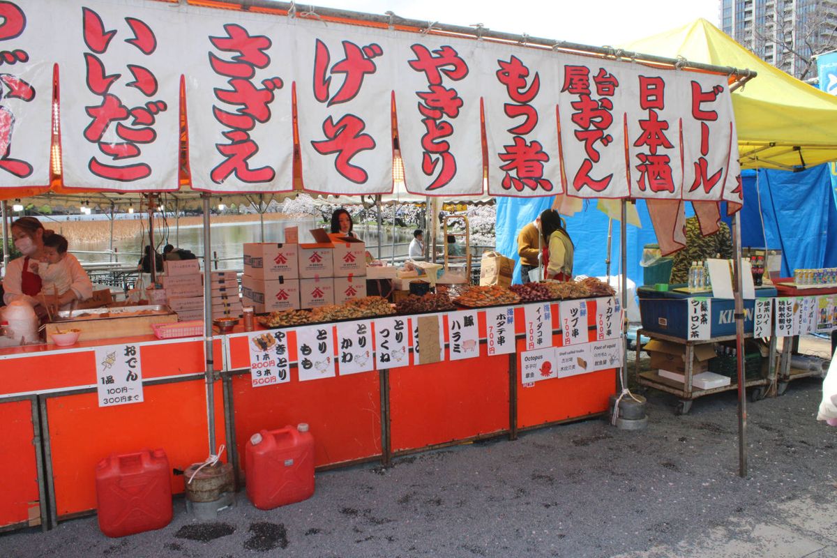 A food stall with red banners